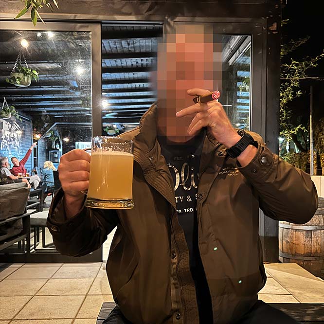 A private investigator enjoys a well-deserved rest after successfully solving a case. He is smoking a cigar and holding a non-alcoholic beer.”